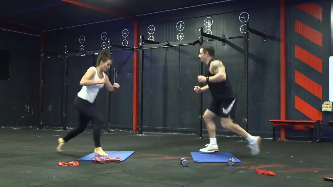 Kadr z treningu CrossFit w domu - siła i tempo z ciężarkami i gumą hip band