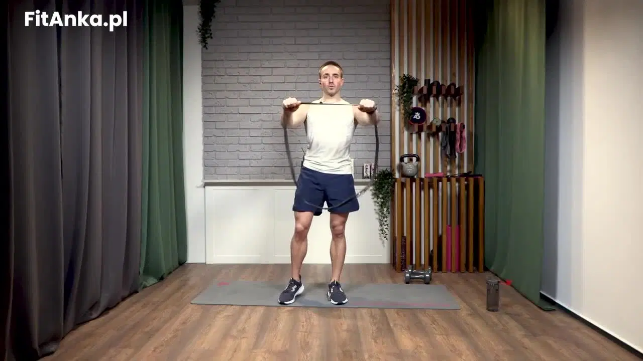 Kadr z treningu CrossFit Kriss - moc i kontrola z gumą power band i ciężarkami