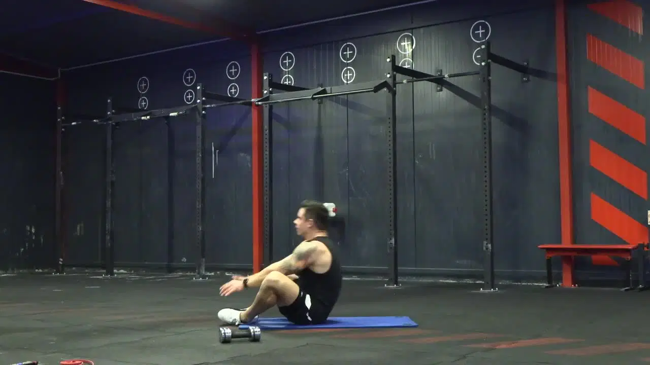 Kadr z treningu CrossFit w domu - wytrzymałość i moc z ciężarkami i gumą power band