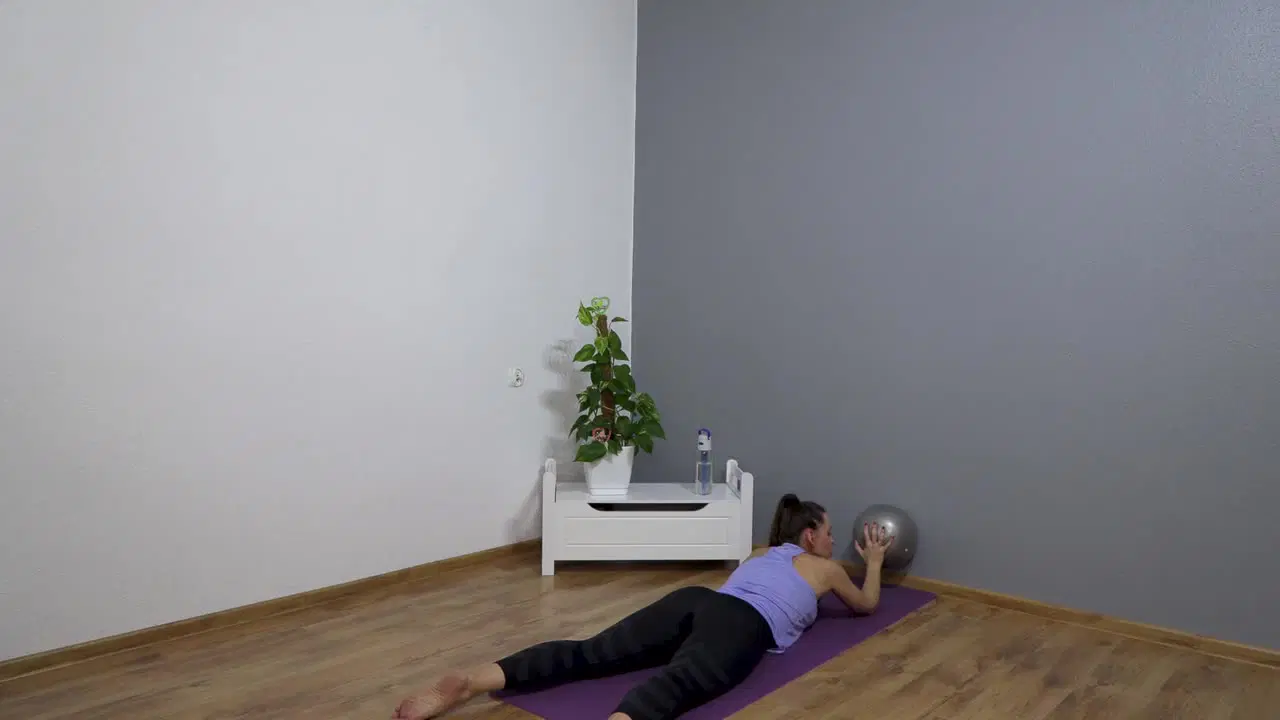 Kadr z treningu Pilates przy ścianie - smukłe ciało - płynny ruch z taśmą pilatesową